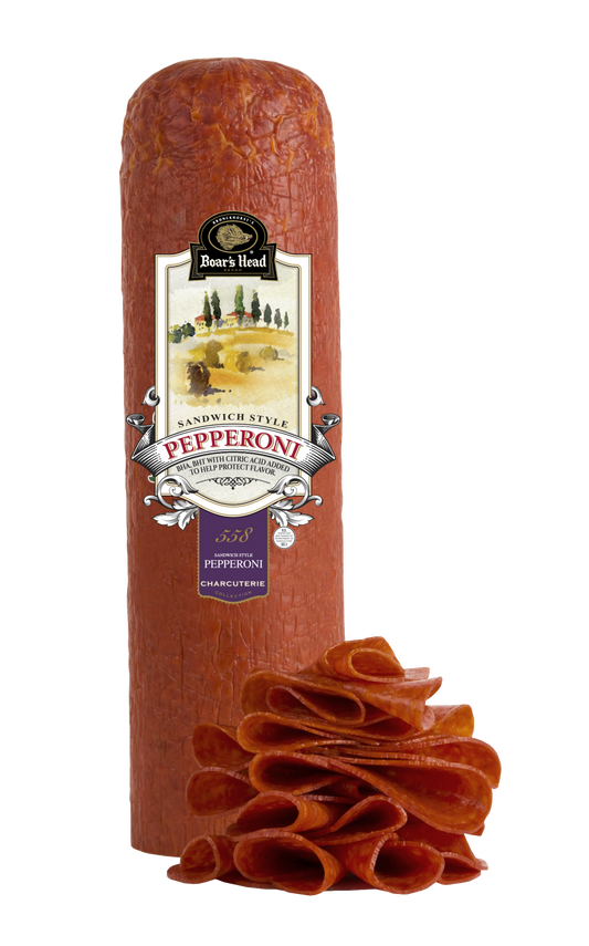 A package of Boar's Head Pepperoni Sandwich Style, featuring a large upright roll of textured red pepperoni with its label facing forward, and a pile of sliced pepperoni rolls displayed in front on a clean white background.